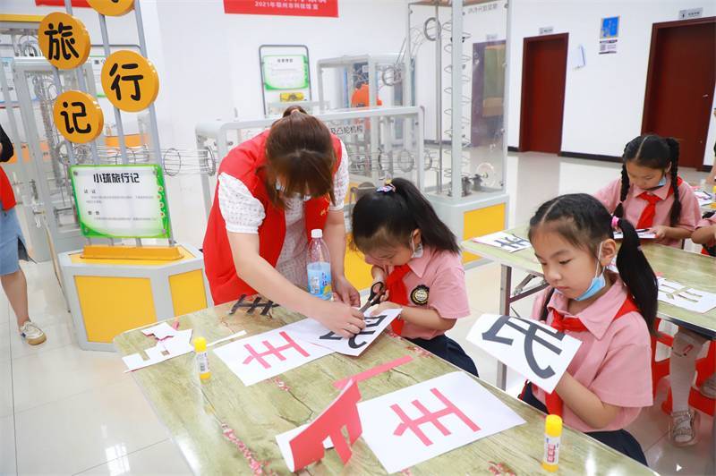 2021年7月10日，鄂州市科協(xié)組織落駕坪小學(xué)學(xué)生在鄂州市科技館開(kāi)展社會(huì)主義核心價(jià)值觀系列活動(dòng)，圖為開(kāi)展的紅色剪影圓夢(mèng)中華剪紙活動(dòng)，志愿者指導(dǎo)同學(xué)們.jpg