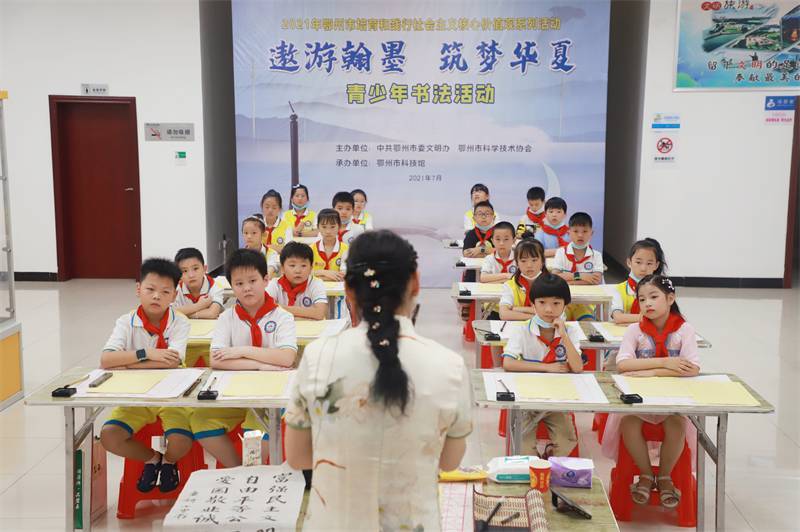 2021年7月10日，鄂州市科協(xié)組織蓮花小學(xué)學(xué)生在鄂州市科技館開展社會主義核心價值觀系列活動，圖為開展的遨游翰墨筑夢華夏書法活動，老師講解握筆姿勢2.jpg